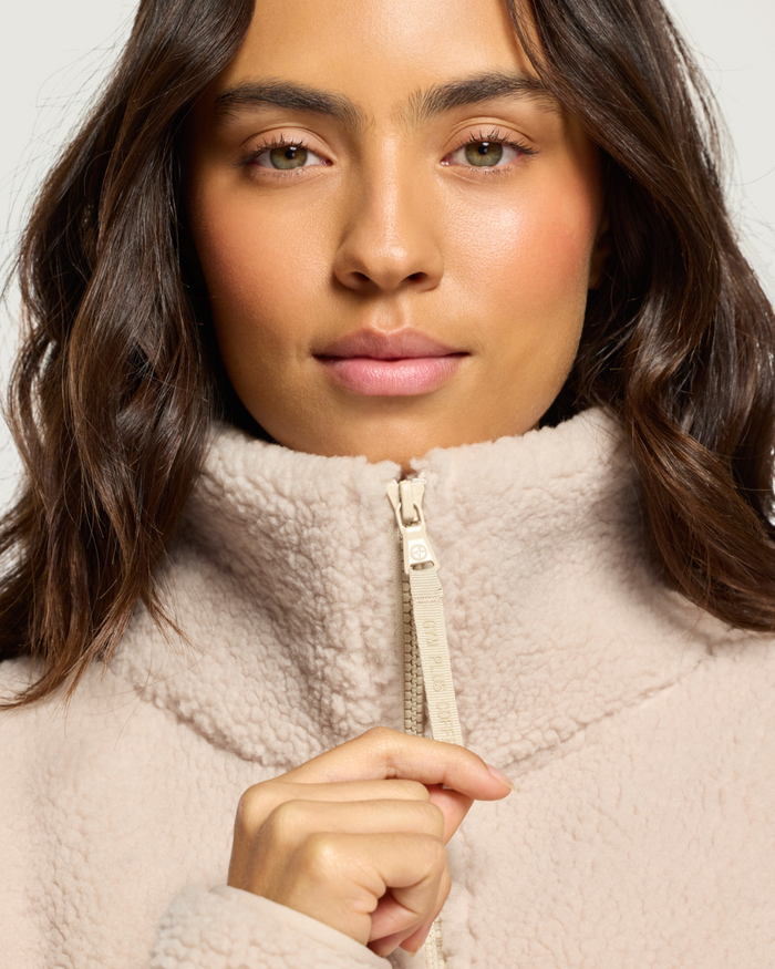 Close up of woman wearing Gym+Coffee Industry Fleece High Collar Jacket Natural Shop Gym+Coffee at Dotique