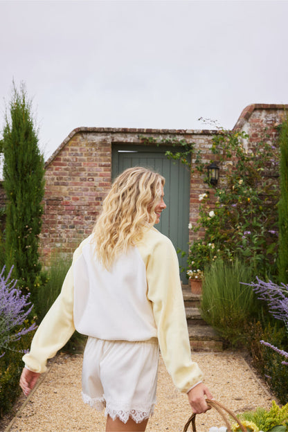 Back view of model wearing Gym+Coffee Snap Polar Fleece Pale Vanilla in garden Shop Gym+Coffee at Dotique