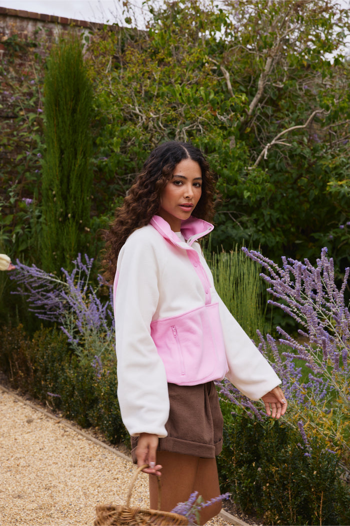 Gym+Coffee Snap Polar Fleece Pink Blossom worn by woman in garden Shop Gym+Coffee at Dotique
