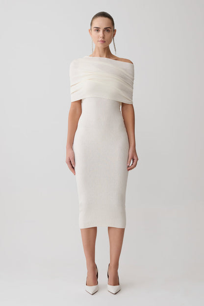 Woman wearing a white off-shoulder dress on a light gray background